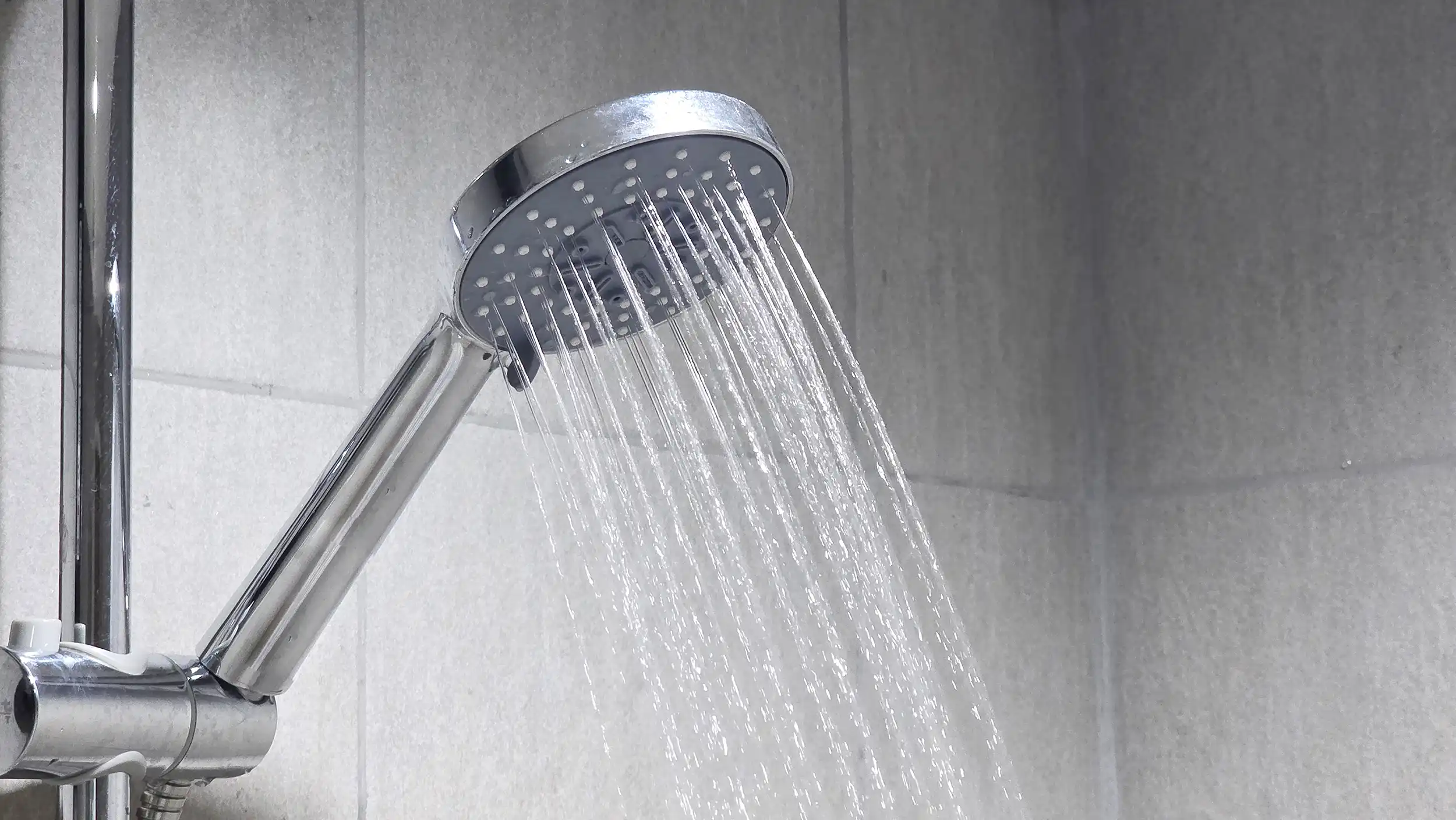 A shower head with water flowing from it.
